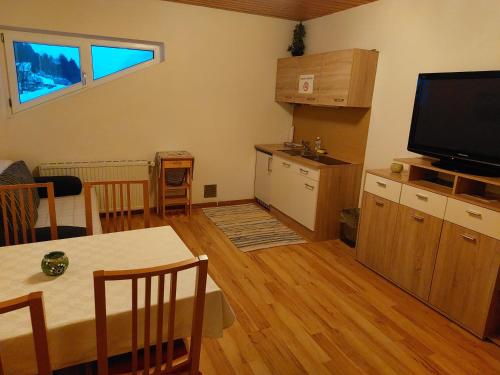 a living room with a dining table and a television at Ferienwohnung Lassing in Lassing