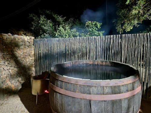 ein Holzfass neben einem Holzzaun in der Unterkunft Stone Cottage Riebeek Valley in Riebeek-Wes