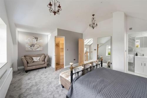 a bedroom with a bed and a couch and a chair at The Beach Hut in Seasalter