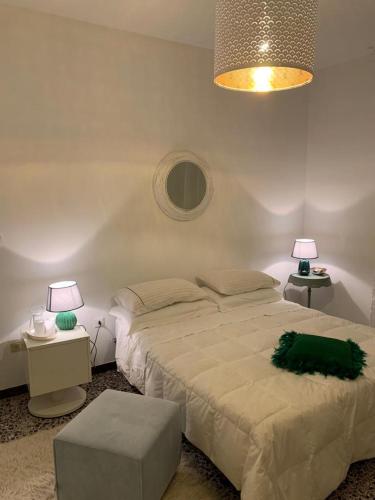 Casa della Piazza في CastellʼAlfero: غرفة نوم بسرير كبير ومصباحين