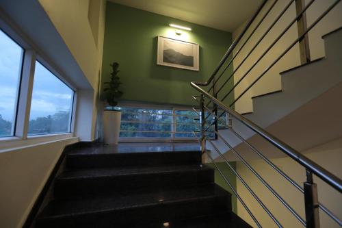 a staircase in a house with a green wall at Earth Hotels in Bengaluru