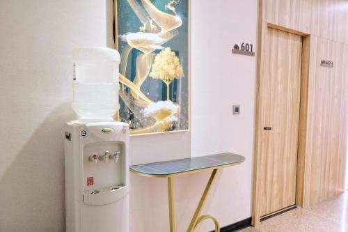 a small table next to a refrigerator in a room at Hoping Mori Hotel in Heping