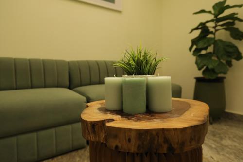 a table with three candles on top of a tree stump at Earth Hotels in Bengaluru