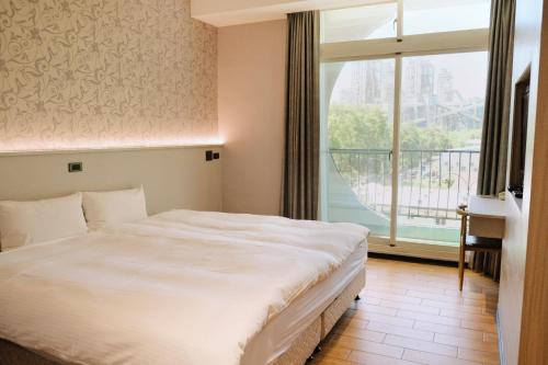 a bedroom with a large bed and a large window at Hoping Mori Hotel in Heping