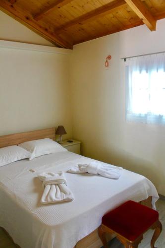 a bedroom with a white bed with towels on it at Διώροφη κατοικία Γλώσσα Σκοπέλου in Skopelos Town