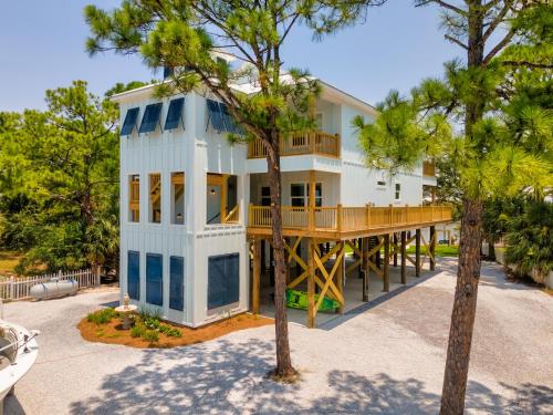 a large white house with a large deck at Island Soul Rendezvous Bay Villa - Unit 4 - 500 Lemoyne condo in Dauphin Island