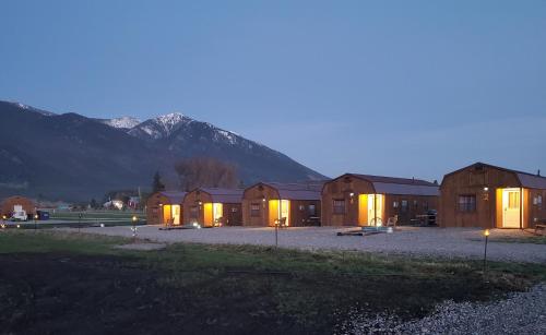 a group of buildings at night with a mountain at Glacier Acres Guest Ranch in Columbia Falls