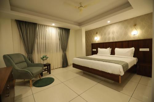 a hotel room with a bed and a chair at Earth Hotels in Bengaluru