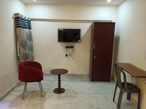 a room with a table and a chair and a tv at Hotel HCB (Hemo Chandra Bhawan) in Brahmapur