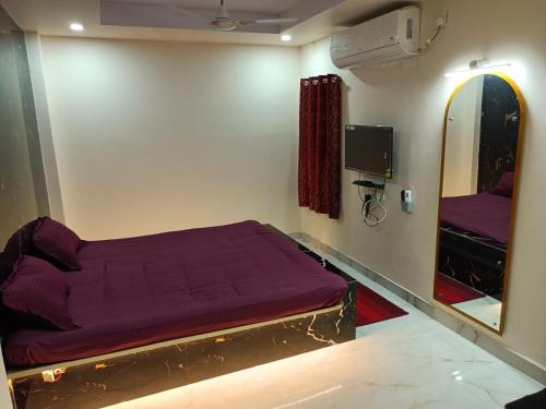 una camera con letto viola e specchio di Hotel HCB (Hemo Chandra Bhawan) a Brahmapur