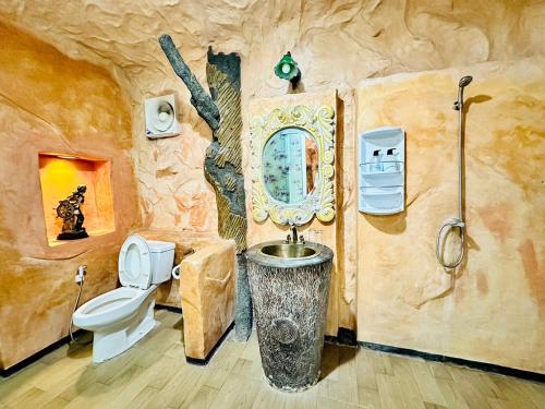 a bathroom in a tree house with a toilet and a sink at Yoko River Kwai Resort in Sai Yok