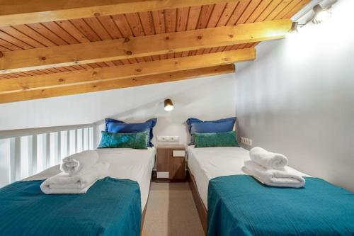 two beds in a room with blue and white at Rena's Rustic retreat in Chania Town