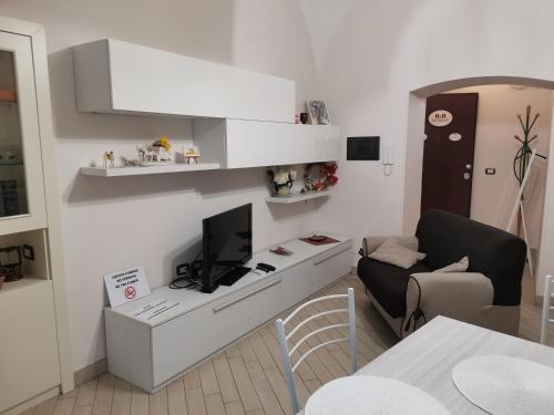 a living room with a desk with a tv and a chair at B&B MaryGe in Ercolano