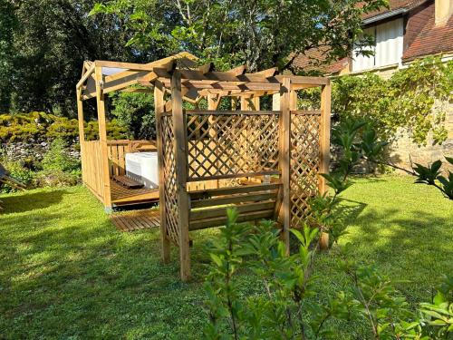 a wooden gazebo in the grass in a yard at Le Domaine de la Claire Fontaine Gîtes -chambres d'hôtes in Montvalent