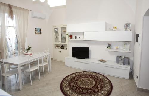 a kitchen and dining room with a table and a television at B&B MaryGe in Ercolano