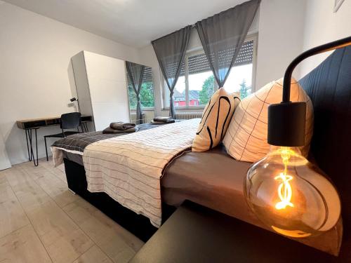 um quarto com uma cama grande e um candeeiro. em Gemütliche Wohnung mit Stil 5 Sterne em Mönchengladbach