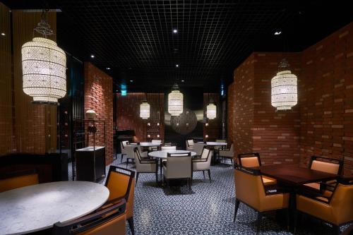 a dining room with tables and chairs and chandeliers at Novotel Ambassador Seoul Gangnam in Seoul