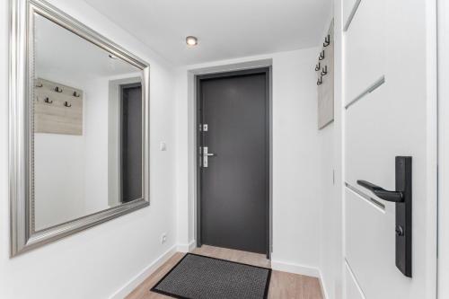 a hallway with a black door and a mirror at Świętokrzyska 16 (E-G) by Homeprime in Warsaw