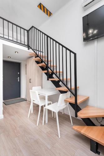 a staircase in a room with a table and chairs at Świętokrzyska 16 (E-G) by Homeprime in Warsaw