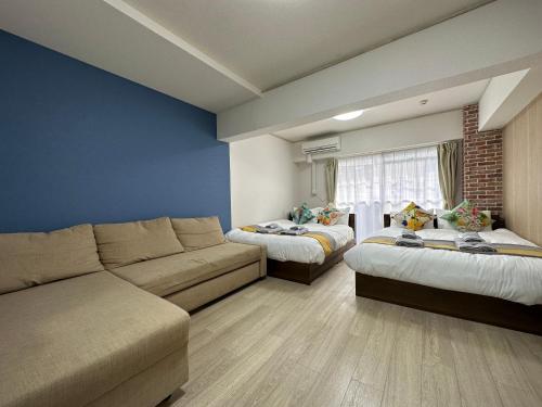 a living room with two beds and a couch at nestay apartment tokyo otsuka in Tokyo