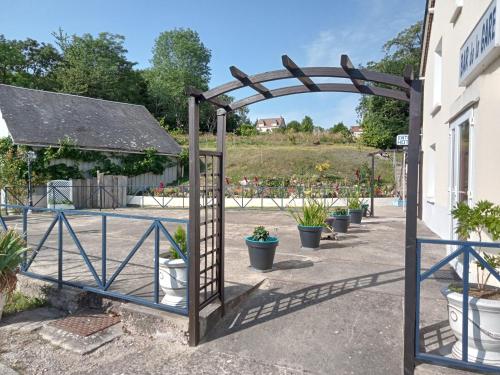 an entrance to a garden with a gate and potted plants at Hôtel Restaurant de la Gare (Studios Du Breuil) in La Roche-Posay