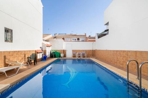una piscina de agua azul en un edificio en Azahar house en Formentera del Segura