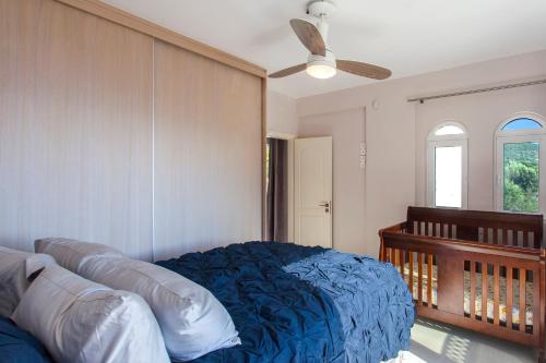 een slaapkamer met een bed en een plafondventilator bij luxurylefkadavilla in Vasiliki