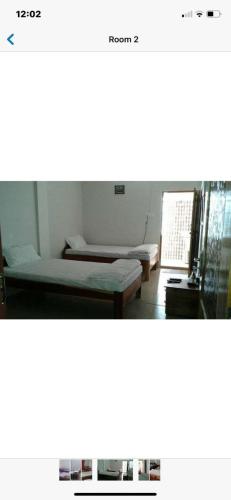 Zimmer mit 2 Betten und einem Tisch in der Unterkunft Tannery Homestay in Cherrapunji