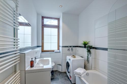 Baño blanco con lavabo y aseo en Kaza Guesthouse, centrally located 2 & 3 bedroom Apartments in Augsburg, en Augsburg