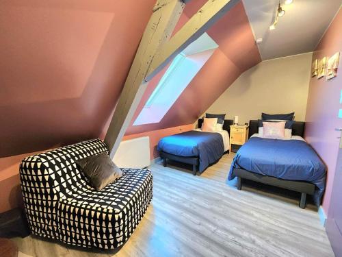 a attic room with two beds and a couch at Le Domaine du Templier - Maréchal in Borre