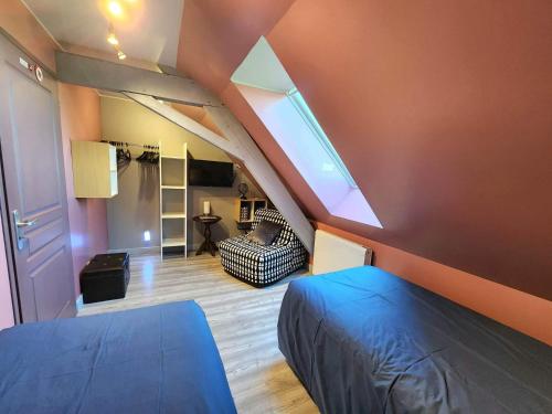 Habitación en el ático con cama azul y sofá en Le Domaine du Templier - Maréchal en Borre