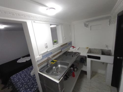 una pequeña cocina con fregadero y encimera en cerca a embajada americana Corferias centro club militar 201, en Bogotá