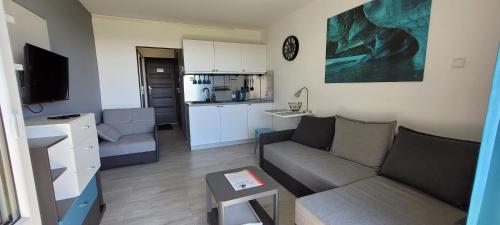 a small living room with a couch and a kitchen at Sea Power Horyzont Apartament 25 PICCOLO in Jastrzębia Góra