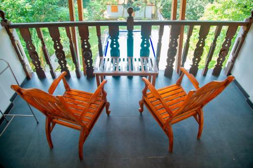 two chairs and a table on a balcony at Rockery Villa Ayurveda in Bentota