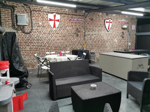 a room with a table and chairs and a brick wall at Le Domaine du Templier - Maréchal in Borre