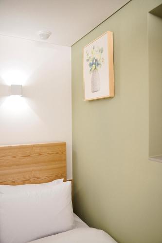 a bedroom with a bed and a picture on the wall at SimpleStay Hotel in Jongno in Seoul