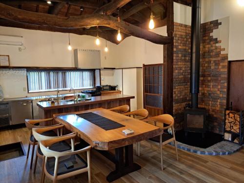 uma cozinha com uma mesa e cadeiras de madeira e um fogão em Former Residence Vacation Rental Minamijuan - Vacation STAY 57751v em Tateyama