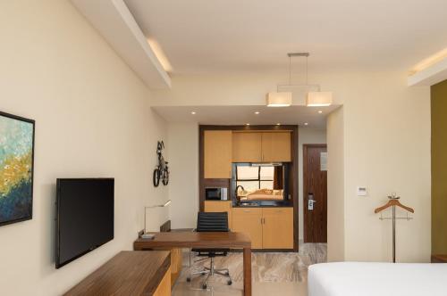 a living room with a desk and a tv at Element by Westin Hotel Dar es Salaam in Dar es Salaam