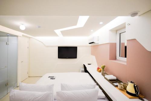SimpleStay Hotel in Jongno في سول: غرفة نوم بسرير وتلفزيون في السقف