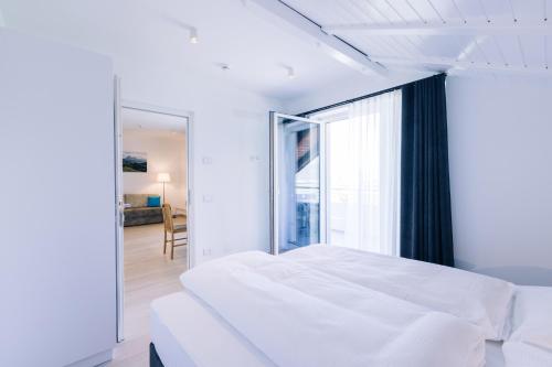 ein Schlafzimmer mit einem weißen Bett und einem großen Fenster in der Unterkunft Residence Martinelli in Leifers