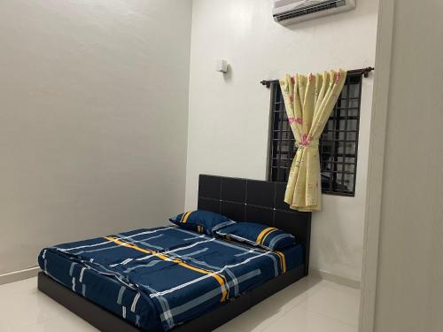 - une chambre avec un lit doté d'une couette bleue et d'une fenêtre dans l'établissement Ms orked homestay penang batu ferringhi no 2, à Batu Ferringhi