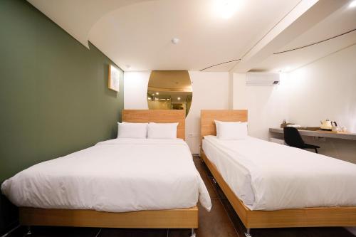 two beds in a small room with a desk at SimpleStay Hotel in Jongno in Seoul