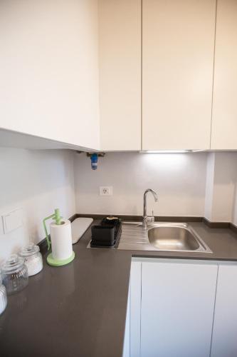 a kitchen with white cabinets and a sink at David Sweet Suite in Florence