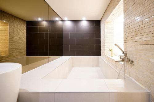 a bathroom with a tub and a sink at SimpleStay Hotel in Jongno in Seoul