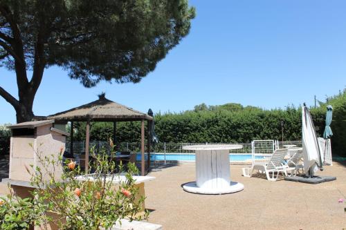 a patio with a table and a gazebo and a pool at Casa con Piscina Privada y Barbacoa en Chiclana Capacidad hasta 10 personas in Chiclana de la Frontera