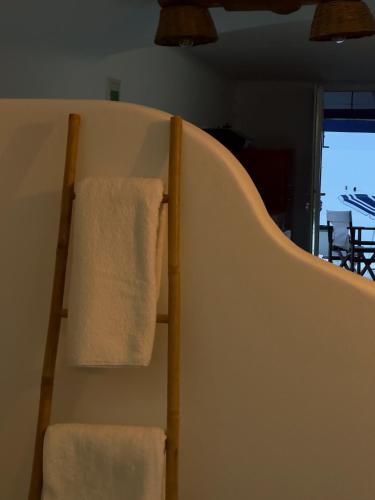 um par de toalhas penduradas num toalheiro num quarto em Cave Beach House Milos em Provatas