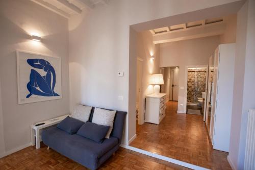 a living room with a blue couch and a hallway at David Sweet Suite in Florence