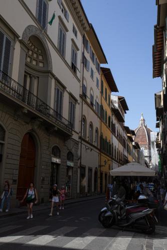 a street with buildings and a scooter parked on the street at David Sweet Suite in Florence
