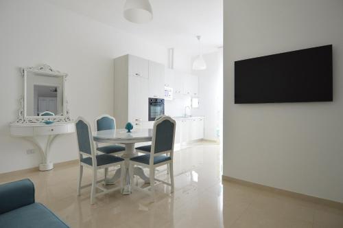 a dining room with a table and chairs and a tv at Balcone in Valle d'Itria in Martina Franca