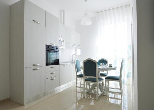 a kitchen with white cabinets and a table and chairs at Balcone in Valle d'Itria in Martina Franca